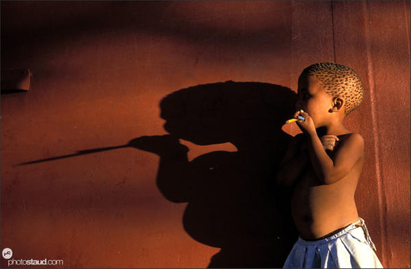 Little girl and shadow in Den/ui village, Bushmanland, Namibia